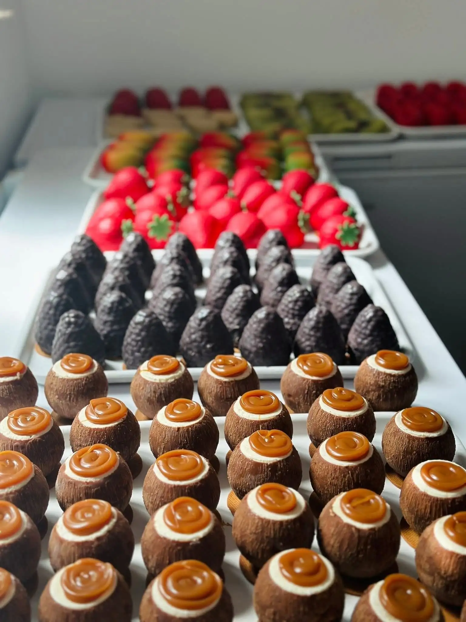 Tăvi cu prăjituri fine — căpșuni, fructe glazurate și choux cu caramel