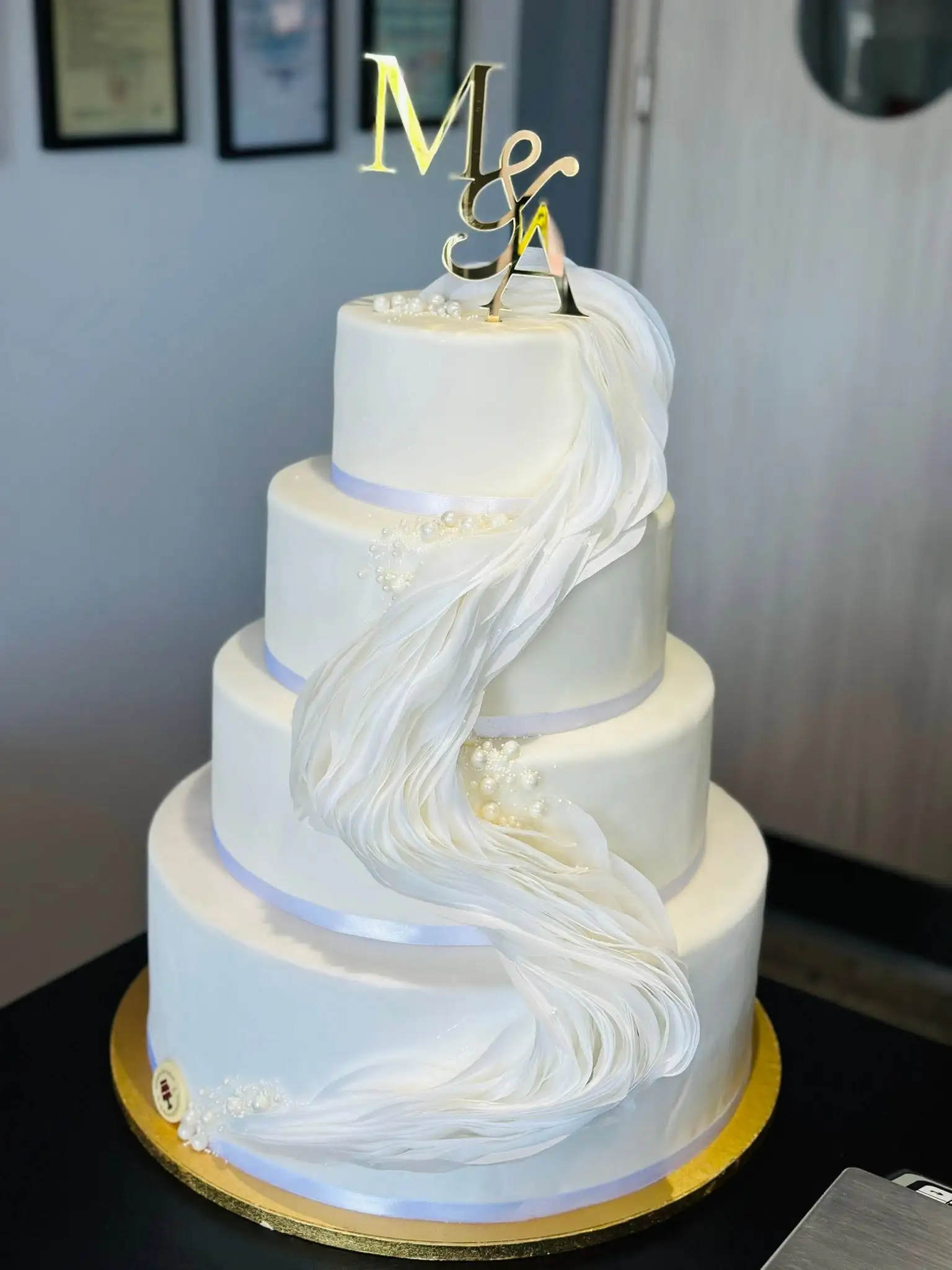 Tort de nuntă alb, etajat, cu perle și voal de zahăr și monogramă M&N